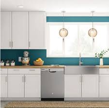 The white tile backsplash and gray cork flooring add layers of neutrals. Kitchen Cabinet Buying Guide
