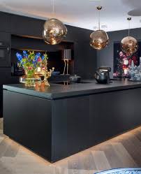 matzwart kookeiland met ronde lampen van goud glas en fleurige woonaccessoires keuken keuken in woonkamer keuken ontwerpen