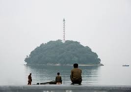 People Sitting And Looking At Seaside Island Hamhung North Korea Life In North Korea North Korea Beach Resorts