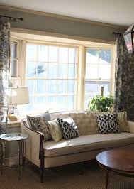 This warm gray living room is a master class in how to illuminate a large space in an interesting way. Our Den Bay Window Living Room Living Room Remodel Quality Living Room Furniture
