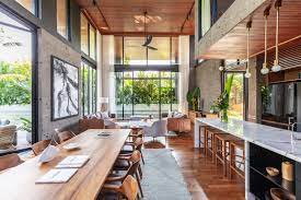 This is the view from the beach of this tropical style home that has modern white structures that are dominated by right angles and abundant glass walls in order to showcase the wonderful beach view accessed through the backyard that has tall tropical trees dancing with the. River House History In The Making Bali Interiors Tropical House Design Bali Interiors Bali House