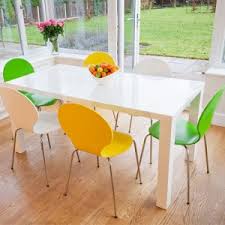 Our collection of tables come in a multitude of sizes, finishes and expressions, making them an ideal fit for dining settings and home offices alike. White Tables And Funky Coloured Chairs Danetti