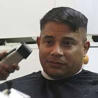 Ship's Serviceman Seaman Lashea Harris gives Logistics Specialist 2nd Class  Joeven Grepo a haircut in the barbershop aboard the amphibious assault ship  USS Boxer (LHD 4).