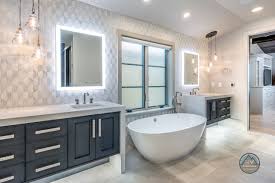 Brushed nickel shower head with digital shower valve, victoria and albert bathtub, curbless shower with hidden shower drain, flat pebble shower floor, shelf over tub with led lighting, gray vanity with drawer fronts. Bathroom Tile Ideas Tips For Choosing Tile Combinations