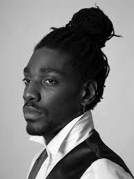 Black Braided Hair In A Bun White Shirt Medium Short Haircuts Black And White Photo Black Hair Bun Man Bun Hairstyles Man Bun Curly Hair