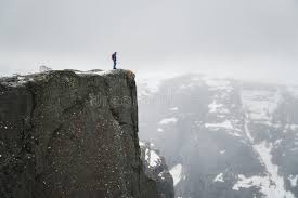 Lonely Man On Rock Traveller Standing On High Edge Of Cliff And Looking At Mountains In Mist Stock Image Image Of Rock Toned 142142509