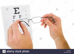 Glasses Held Up To Read Eye Test On White Background Stock