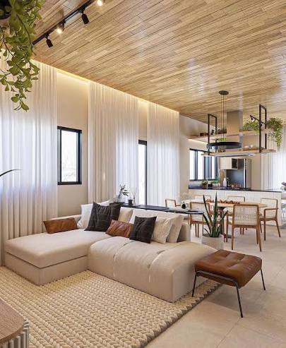 🏠 Sala de estar integrada com textura madeira no teto! 💡 A iluminação embutida cria um clima acolhedor, enquanto a cortina leve possibilita entrada suave de luz natural. ✨ Dica: Aposte em