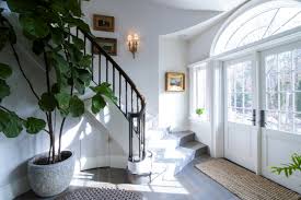 The team steps in to give a plain ranch home some modern moroccan. New Photography A Colonial Revival Foyer Featuring A Grand Curved Cooper Preassembled Staircase Horner Millwork