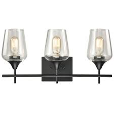 The modern farmhouse vanity is using a polished chrome finish that creates the perfect Monaco Farmhouse Bathroom Vanity Lights 3 Light Clear Glass Wall Sconces Matte Black Finish Overstock 33054852