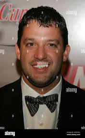 Race car driver Tony Stewart, center, takes a shot during a basketball game  at the Carmelo Anthony Center at Syracuse University in Syracuse, N.Y.,