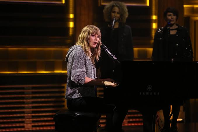 Taylor Swift delivering a powerful, heartfelt performance from the piano., do AI tạo