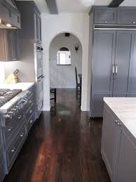 The white kitchen cabinets look gorgeous against the dove gray walls and the deep cheery wood flooring. Pin By Runfrmitall On Home Design Decor White Cabinets Kitchen Dark Floors Dark Grey Kitchen Grey Flooring