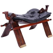 Camel saddle foot stool crafted in mahogany with two carved camels at the top, dark chocolate brown leather button tufted cushion, and splayed legs decorated with floral brass. Pin On Diy