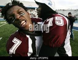 Fulton quarterback Dennis Freeney (7) yells as teammate Rodney Simms (75)  gives him a hug while celebrating their win over David Lipscomb in the  Division I class 3A championship high school football