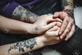 Download the perfect hand tattoo pictures. Young Couple In Love Tattoos Cuddling And Holding Hands Stock Photo Picture And Royalty Free Image Image 54308381
