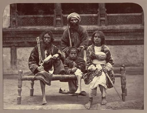 Pakistan - Group of beggars Kabul, 1879 (c). Photograph of a family of beggars seated on a string bed, taken by John Burke in Kabul, Afghanistan, C.1879-80, in the period of the