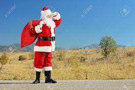 D'un mouvement de la main, je lui confirme qu'il est attendu … il arrive en traînant les pieds et se plante devant moi qui prends un air sévère. Portrait En Pied D Un Pere Noel Tenant Un Sac Plein De Cadeaux Sur Une Route Ouverte Et La Recherche Banque D Images Et Photos Libres De Droits Image 22553721