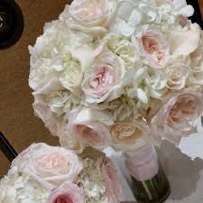 Soft blush pink garden roses and peony buds are accented with ivory hydrangeas and tied with ivory satin ribbon. White Hydrangeas And Blush Garden Roses Bridal Bouquets