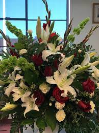 Lovely Urn Arrangement For A Funeral Includes Bells Of Ireland Red Roses White Oriental Lilies Funeral Flower Arrangements Funeral Flowers Sympathy Flowers