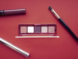 Premium Photo A Set Of Makeup Products Including Eyeshadow Lip Gloss Mascara Makeup Brush And Highlighter On Red Background Beauty Concept
