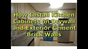 Begin with a corner hanging cabinet or the one on the far left if you don't have a corner unit. How To Install Kitchen Cabinets On Interior Stud Walls And Exterior Cement Brick Walls Youtu Installing Kitchen Cabinets Installing Cabinets Kitchen Cabinets