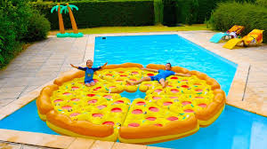 Pizza Geante Dans La Piscine Children Play With A Giant Inflatable Pizza In Swimming Pool Youtube