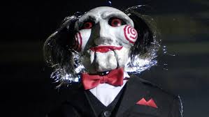 A su lado, hay otra persona encadenada, el dr. Saw Viii Jigsaw Sigue Jugando La Cronosfera