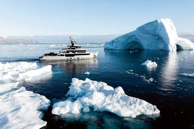 A lone explorer navigating icy Arctic waters in a small vessel.