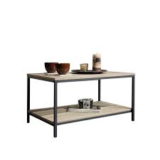 This piece features a casual contemporary design with sharp lines, recessed panels, and clipped block feet. Sauder North Avenue Engineered Wood And Metal Coffee Table In Charter Oak 420275