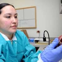 Personnel Specialist 3rd Class Nia Partee, right, issues money to Personnel  Specialist 3rd Class Nyashe Benjamin-Johnson at the disbursing window  aboard the aircraft carrier USS George H.W. Bush (CVN 77).