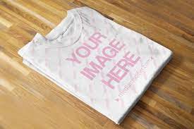 Download Folded T Shirt On Wood Background Mockup Mediamodifier