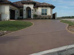 Modern yellow house with yellow and grey exterior along with a small garden area and a stamped concrete driveway. Stained Concrete Driveways Patios Sidewalks Garages Stained Concrete Driveway Concrete Driveways Driveway Design