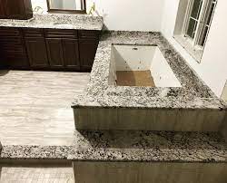 Whether you choose to contrast your tile with your tub or to coordinate the two will affect the overall feeling of the room. Gorgeous Granite Whirlpool Tub Surround And Vanity A Bella Countertops