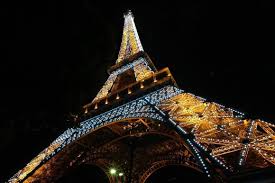 Eiffel tower brightly illuminated at night in paris, france. Taking Photographs Of The Eiffel Tower At Night Is Actually Illegal