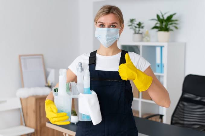 Professional cleaning team performing a detailed move-out cleaning in an empty home, sanitizing kitchen countertops, scrubbing bathrooms, vacuuming floors, and wiping baseboards before the next occupants arrive. The image showcases Naturally Maid Cleaning Co. providing expert move out cleaning, move out house cleaning, and move out cleaning services near me with exceptional attention to detail.
