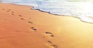 Feet leaving footprints on the sand of the beach waves reaching the sand beach paradise beach with pinkish sand Footprints In The Sand Poem Meaning Biblical Hope