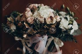 Bouquet on wooden bench with bride and groom in the background, focus on the flowers. Stylish Wedding Bouquets For Bride And Bridesmaids Luxury Roses Stock Photo Picture And Royalty Free Image Image 75805338