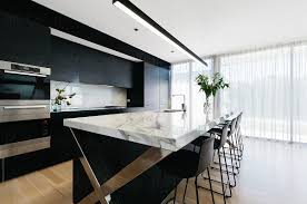Cool marble with natural grey veining stabilizes the base of this freestanding paper towel holder for simply elegant utility in the kitchen. Luxury Open Plan Black Kitchen With Calcutta Marble Benchtop By Jodie Johnson Photography Interior Kitchen