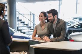 • arrange for car dealers, or. Portrait Smiling Confident Female Receptionist Working At Desk In Car Dealership Showroom Stockphoto