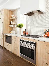 View full size between brown oak kitchen cabinetry, stacked gray floating shelves are mounted against white subway wall tiles above a coffee station placed atop gray cabinets. 5 Fresh Looks For Natural Wood Kitchen Cabinets