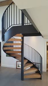 The use of collars, essentially a solid ring attached to the step itself so the two are one solid piece, allows a simple assembly for your stair as such collars slide right over center support columns like perfectly fitted rings over a finger. This Latest Spiral Installation Is In Perfect Contrast With Solid Wood Treads Off Set By The Black Metal Spiral C Spiral Staircase Staircase Design Water House