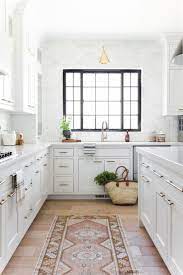Warm walnut solid wood floors and light beige walls create a warm background for the whole kitchen, which helps soften the white surfaces. New Arrivals Just In Time For Spring Studio Mcgee White Kitchen Design Modern Kitchen Design Interior Design Kitchen