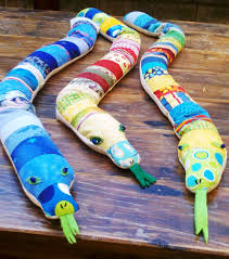 door snakes made from 5 wide quilt scraps sewn together to make a snake backed and filled with sand with added eyes and fan quilt patterns door snake quilts