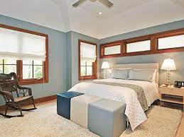 The elegant neutral mimics the color of early morning and provides a restful backdrop to playful patterns and textures, like the plush stool and rich wood furniture in this serene space. Simply White Roman Shades Blue Bedroom Paint Contemporary Bedroom Blue Bedroom