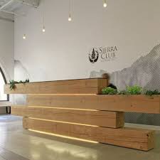 A Plant Filled Stack Of Timber Beams Forms The Reception Desk Of An Environmental Association S H Reception Desk Design Reception Design Office Interior Design