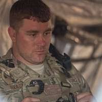 A member of the 2123rd Transportation Company, Kentucky Army National  Guard, carries a photo of 2nd LT. Robert L. Henderson as he returns back  home from Iraq at the 123rd Airlift Wing,