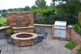 The top of the column houses a wick for the fire with decorative rocks around it. Outdoor Living Room Outdoor Kitchen Fire Pit Custom Water Wall Water Feature Color Falls Denver Landscapes