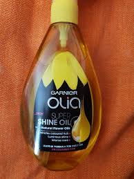 Cosmetic orange bottle with dispenser in hand oil gel hair body on white background isolation. Garnier Olia Super Shine After Colour Hair Oil 150 Ml Inci Beauty