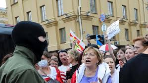 A man in a mask hangs an old belarusian flag on a light pole during an opposition rally to protest the official presidential election results in minsk, belarus. Thousands Of Women In Belarus Continue Protest Pressure Against President Alexander Lukashenko Abc News
